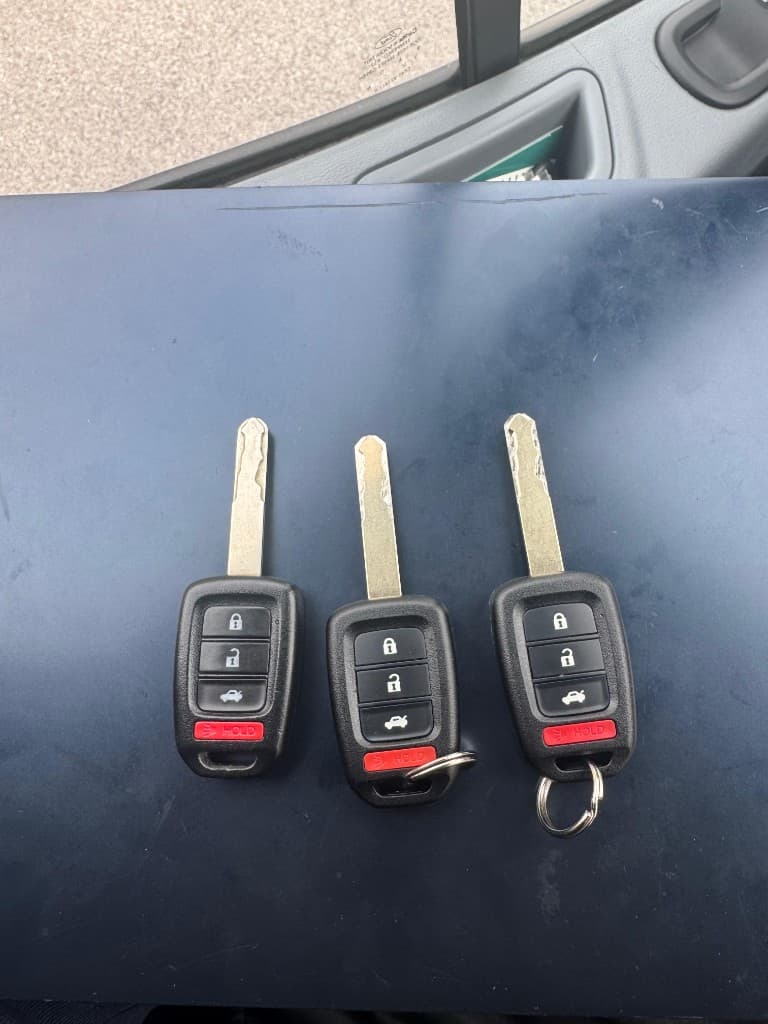 Three black Ford-style key fobs with silver laser-cut blades ready for the customer
